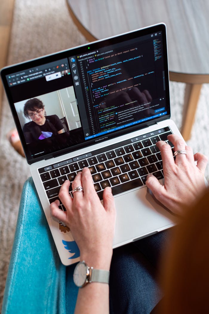 our-mission Person coding on a laptop during a video conference, showcasing remote work.