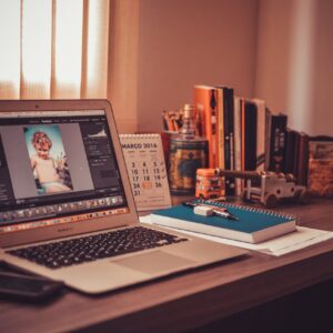 Warm-toned home office desk with a laptop, notebook, and books. Perfect for freelancers.